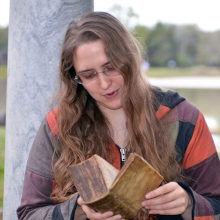 Photo of Ada Palmer reading a very old book